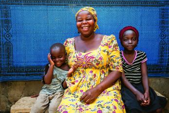 Naomi with two children, seated, smiling