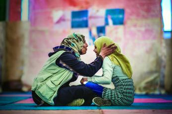 Azeh,12, sits with her favorite teacher at one of mercy corps’ youth spaces in za’atari refugee camp in jordan.