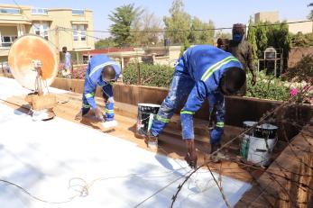 Niger community members repairing a roof.