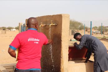 Mercy corps niger employee and community member at washing station.