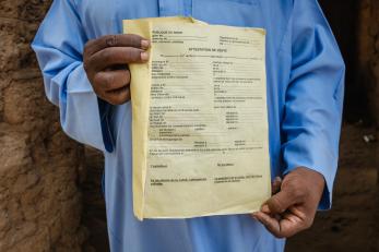 A close-up photo of a man holding a land deed.