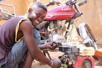 Nigerian man repairing a motorcycle.