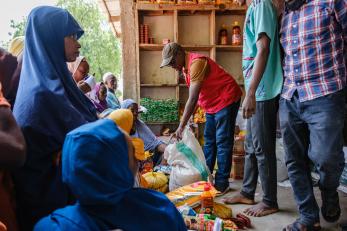 A Mercy Corps member distributing humanitarian aid supplies.