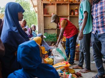 A mercy corps member distributing humanitarian aid supplies.