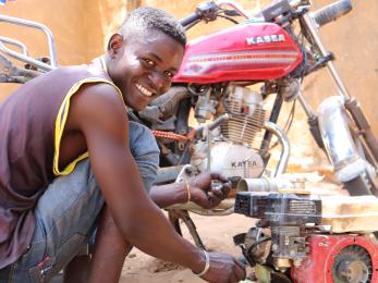 Nigerian man repairing a motorcycle.